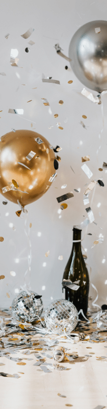 Happy New Year celebration, gold balloons, disco balls, confetti, champagne