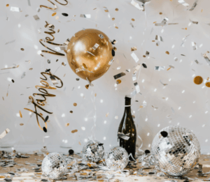 Happy New Year celebration, gold balloons, disco balls, confetti, champagne